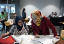 Photo of two women looking at data sheets